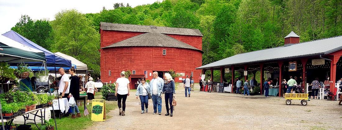 Visitors outside the red Round Barn at Pakatakan Farmers’ Market